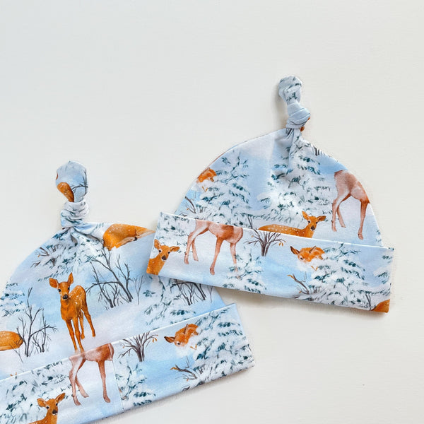 Blauw knoopmutsje met herten in de sneeuw