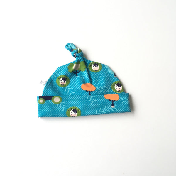 Blauwe baby muts met koeien en bomen. Maat 50 - 56