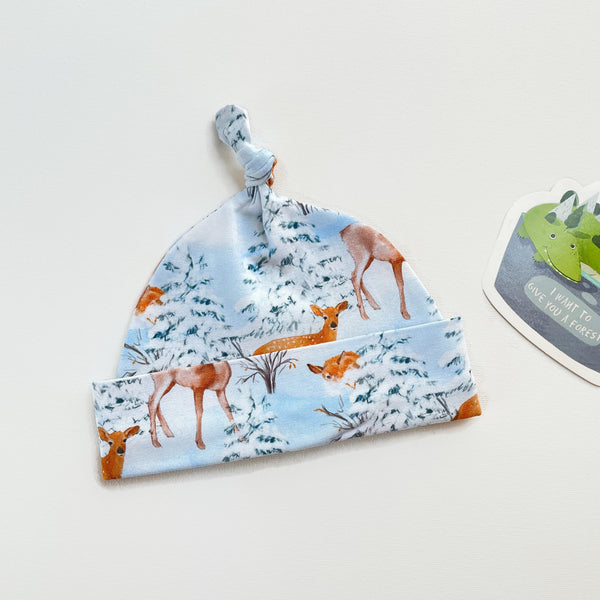 Blauw knoopmutsje met herten in de sneeuw