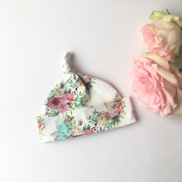 Witte baby muts van katoenen tricot met rozen en eenhoorns. Tweede keus