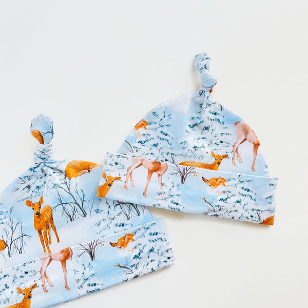 Blauw knoopmutsje met herten in de sneeuw