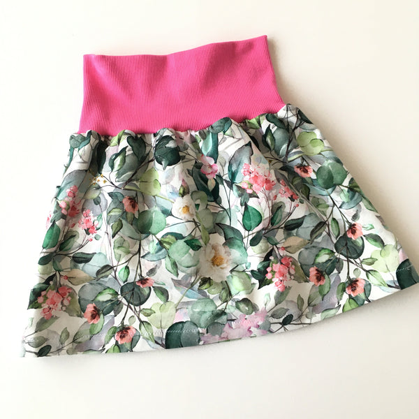 Wit kinderrokje met bladeren en roze bloemen. Maat 104