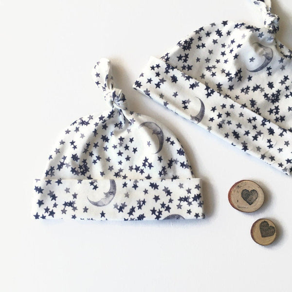 Baby muts van wolwitte tricot met sterren en manen