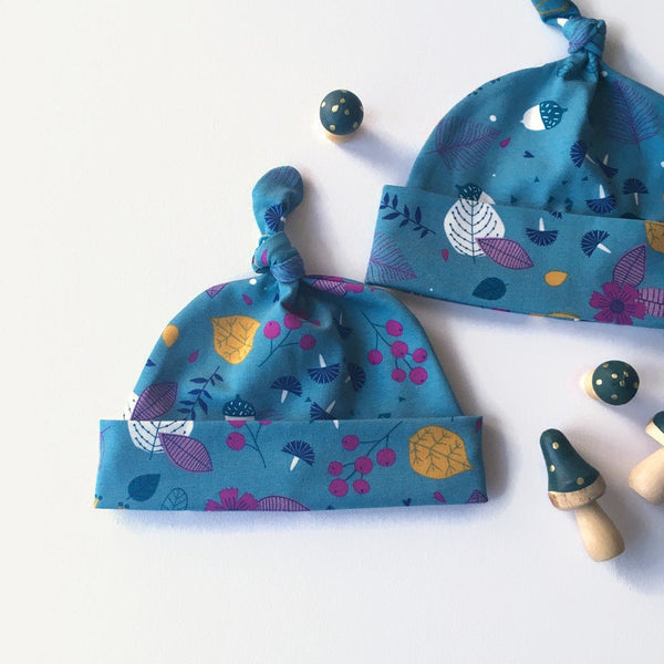 Baby muts van petrol tricot met blaadjes en besjes