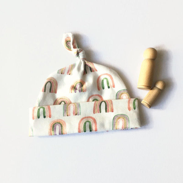 Baby muts van witte tricot met regenbogen