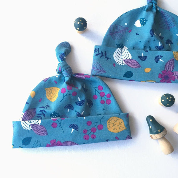 Baby muts van petrol tricot met blaadjes en besjes