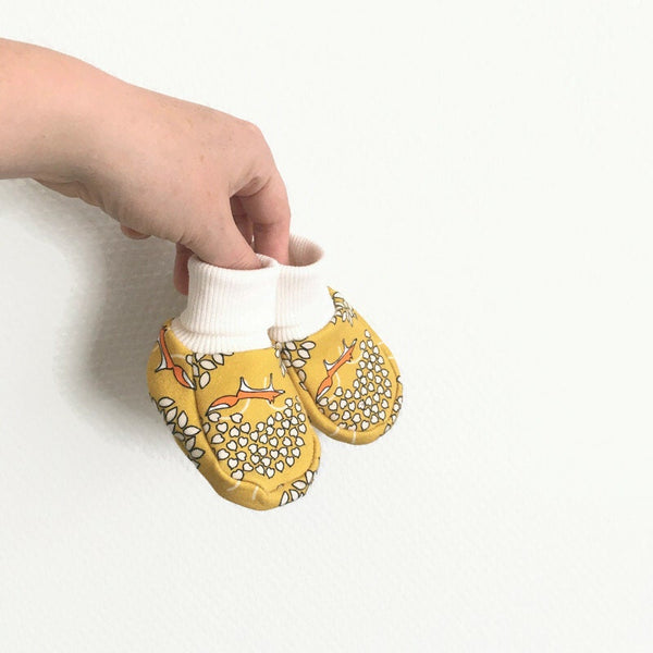 Gele baby slofjes met vossen.