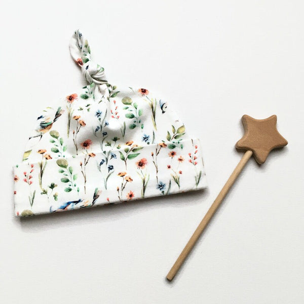 Baby muts van witte tricot met bloemetjes en vogels
