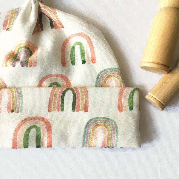 Baby muts van witte tricot met regenbogen