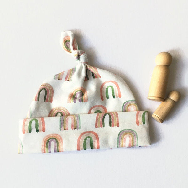 Baby muts van witte tricot met regenbogen