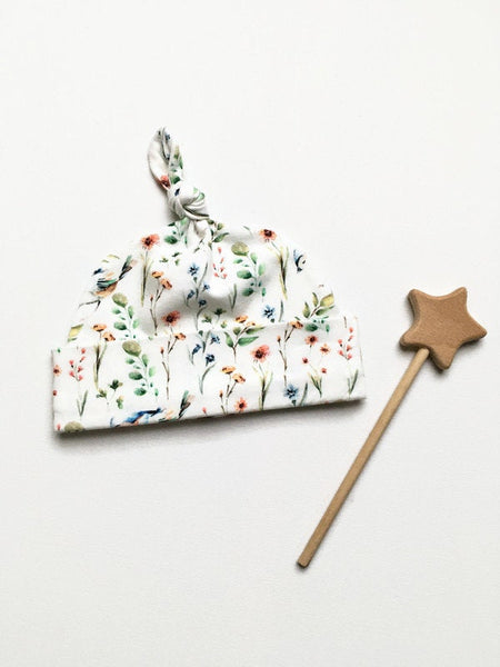 Baby muts van witte tricot met bloemetjes en vogels
