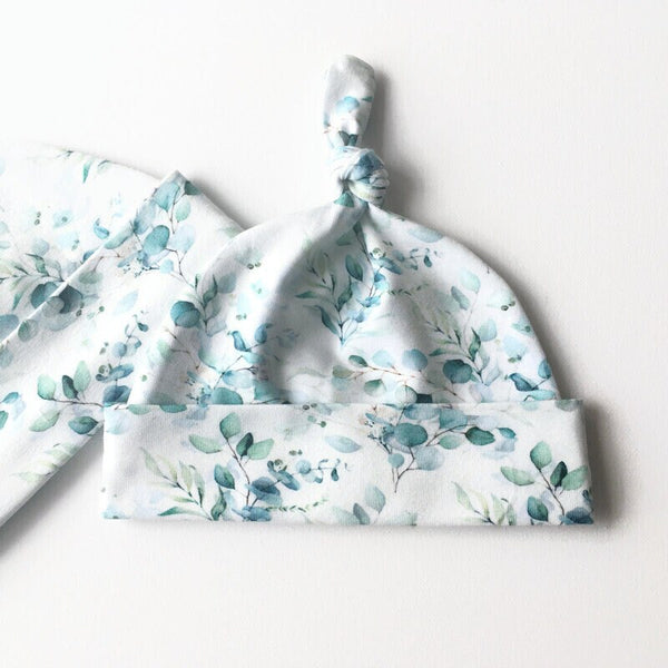Baby muts van witte tricot met zacht groene blaadjes