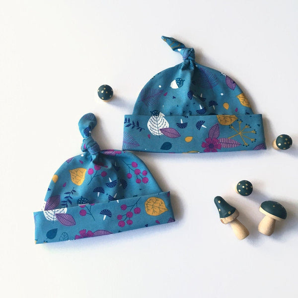 Baby muts van petrol tricot met blaadjes en besjes