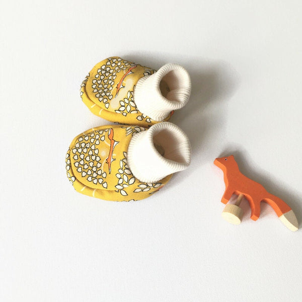 Gele baby slofjes met vossen.