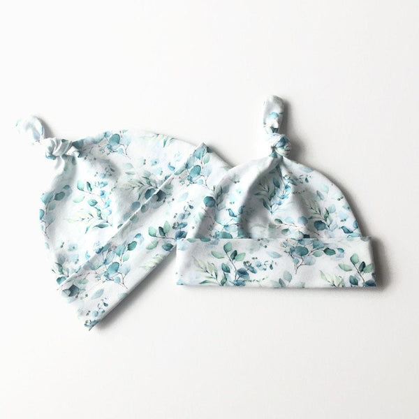 Baby muts van witte tricot met zacht groene blaadjes