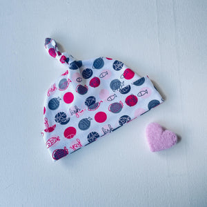 Wit baby mutsje met roze stippen en vissen