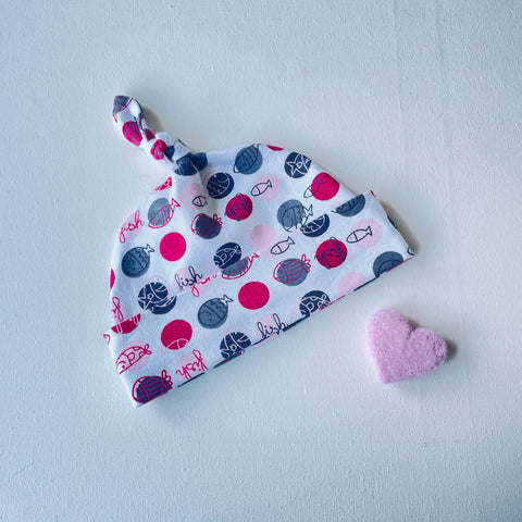 Wit baby mutsje met roze stippen en vissen