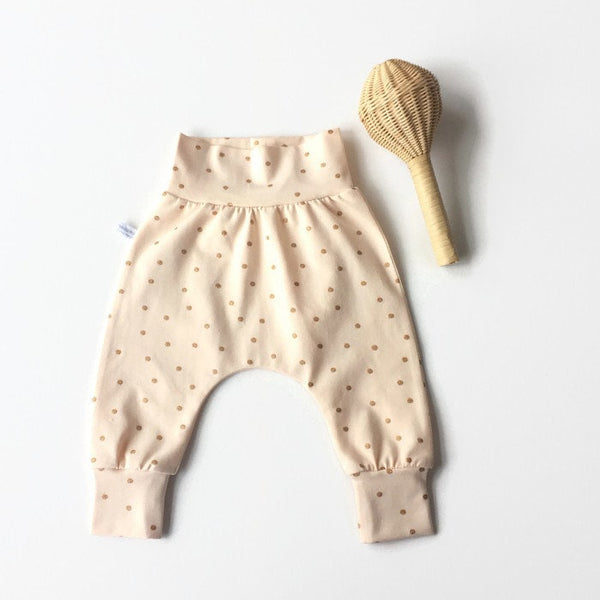 Perzikkleurig baby harem broekje met gouden stipjes. Maat 56