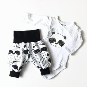 Baby set van witte tricot met panda's. Broek en romper