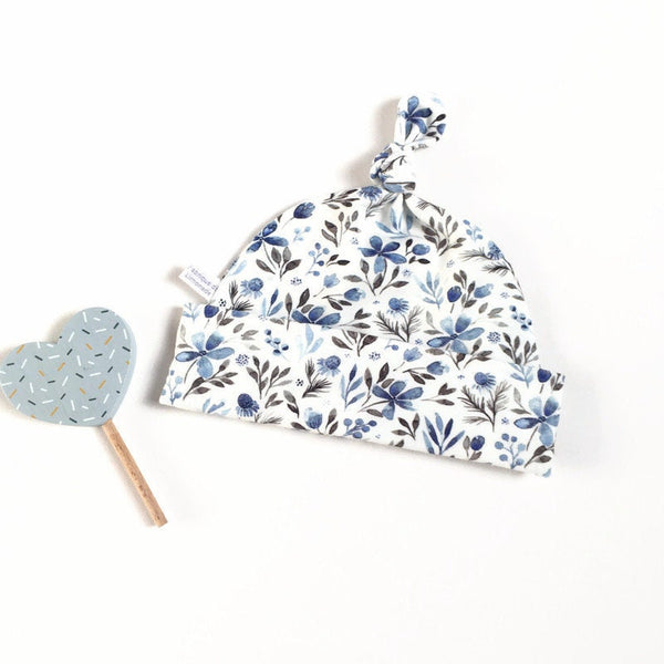 Baby muts van witte tricot met blauwe bloemetjes